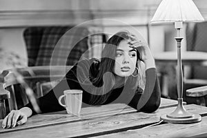 Portrait of a girl. Brunette in a coffee shop. elegant lady in a black dress, in a restaurant alone. Girl in a cafe