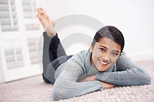 Portrait of girl on carpet with smile, relax and weekend break to unwind in living room at house. Face of woman lying on