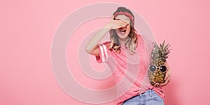 Portrait of a girl with a closed eye on a pink background