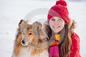 Portrait of girl with collie dog on snow field