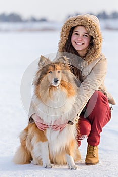 Portrait of girl with collie dog on snowy landscape