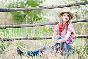 Portrait of the girl - cowboy at an old fence