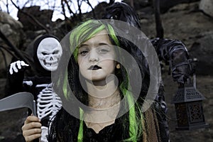 Portrait of girl dressed up as witch while her friends dressed up in skeleton costume