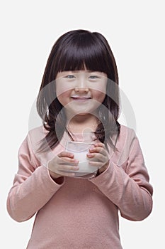 Portrait of girl drinking a glass of milk with a milk moustache