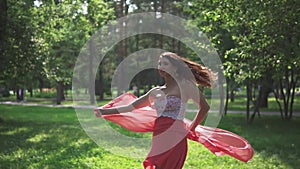 Portrait of a girl with Eastern appearance. Beautiful young girl in red dress posing on a background of green. flowing