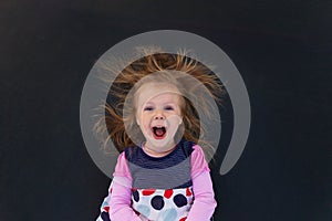 Portrait of a girl with electrified hair on a black background photo
