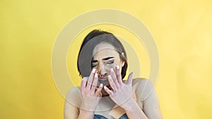 Portrait of the girl with emotion of crying on yellow background in 4K