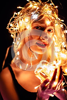 Portrait of a girl with a garland on black background