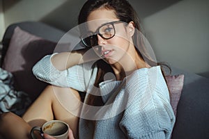 Portrait of girl with glasses holding cup of coffee