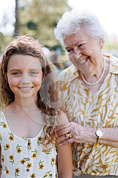Portrait of girl with grandmother at garden party. Love and closeness between grandparent and grandchild.