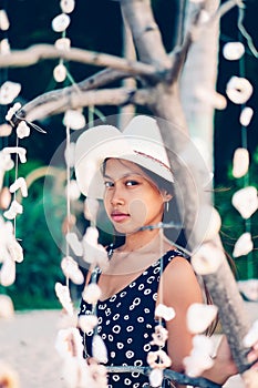 Portrait of a girl among hanging shells decoration on the beac