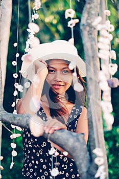 Portrait of a girl among hanging shells decoration on the beac