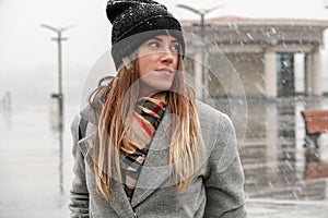 Portrait of a girl in a hat and a gray coat.