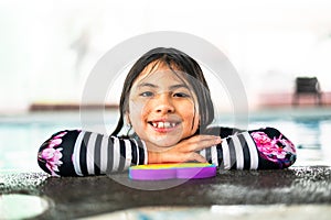 Portrait girl having fun in indoor swimming-pool. The girl is resting at the water park. Active happy kid. Swimming