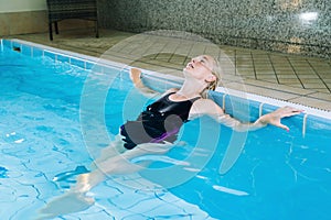 Portrait girl having fun in indoor swimming-pool. The girl is resting at the water park. Active happy kid. Swimming school for