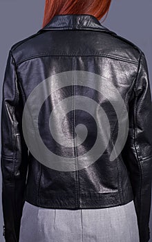 Portrait of a girl in a high-quality leather jacket. Rock and roll style in women. Promotional photo of a leather jacket