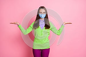 Portrait of girl hold hand copyspace corona virus adverts wear medical mask isolated pink color background