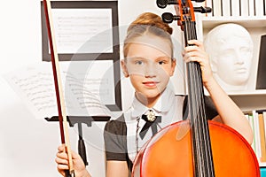 Portrait of girl holding fiddle-bow to play cello