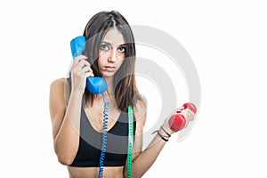 Portrait of girl holding phone receiver and dumbbell
