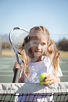 Portrait of girl holding racket and tennis ball