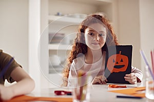 Portrait Of Girl At Home With Friends Having Fun Making Halloween Decorations Together