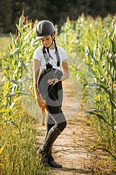 Portrait of a girl - a jockey, who holds a horse - a toy in her hands photo