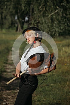 Portrait of a girl - a jockey, who holds a horse - a toy in her hands