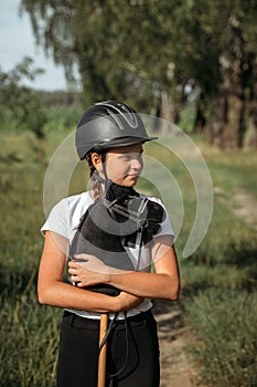 Portrait of a girl - a jockey, who holds a horse - a toy in her hands photo