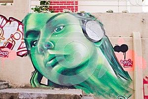Portrait of girl listening music in green graffiti