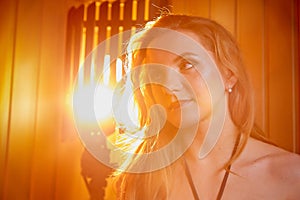 Portrait of a girl with long blond hair in soft red light