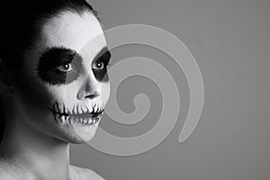 Portrait of girl with make-up for halloween. gray background, isolated. unusual body art. black and white