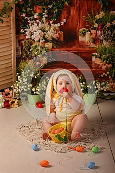 Portrait girl one year old in a bunny costume shooting in the studio in the background flowers wooden background dekor photo