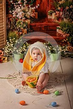 Portrait girl one year old in a bunny costume shooting in the studio in the background flowers wooden background dekor photo