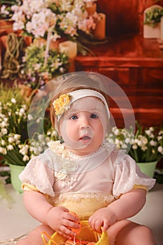 Portrait girl one year old shooting in the studio in the background flowers wooden background dekor