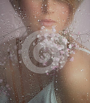 Portrait of a girl on a pink background with flowers. Tenderness and feminine. The sphere of beauty and women& x27;s