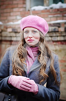 Portrait of a girl in a pink beret and a gray-blue coat