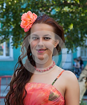 Portrait of a girl in a pink dress with a flower in her hair