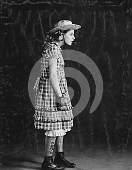 Portrait of girl in plaid dress and straw hat