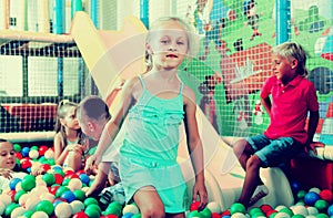 Portrait of girl playing in pool with plastic multicolored ball