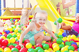 Portrait of girl playing in pool with plastic multicolored ball