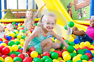 Portrait of girl playing in pool with plastic multicolored ball