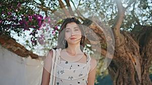 Portrait girl posing summer garden church. Woman touching hair looking camera