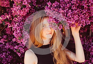 Portrait of girl among purple bougainvillaea photo