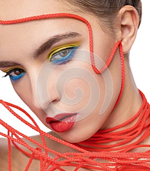 Portrait of a girl with a red rope on her face