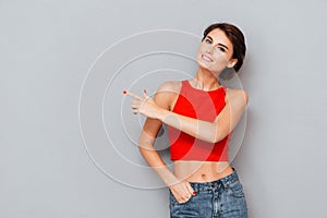 Portrait of a girl in red top pointing finger away