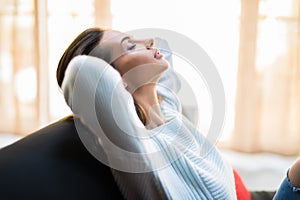 Portrait of a girl relaxing on a sofa after work at home sitting on a sofa in the living room at home with a warm light of sunset