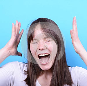 Portrait of girl screaming against blue background