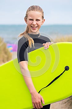 Portrait Of Girl By Sea In Wetsuit Holding Bodyboard