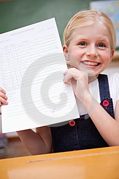 Portrait of a girl showing her school report