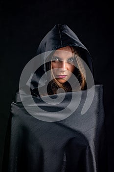 Portrait of a girl in a silk black cloak